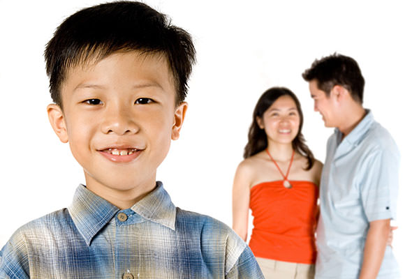 Asian boy with parents in background